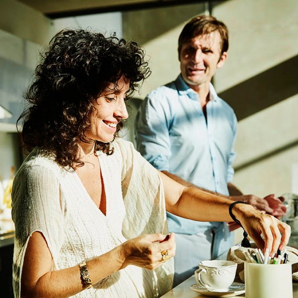 Smiling couple in their sunlit kitchen at home